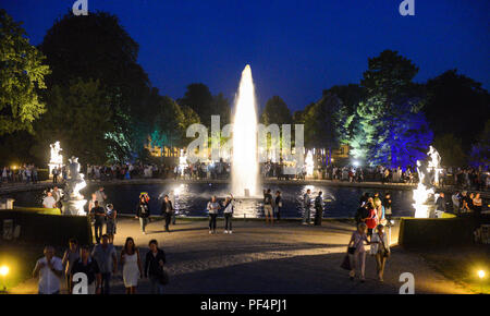 Potsdam, Allemagne. Août 18, 2018. Les visiteurs à pied à travers le parc de Sanssouci Potsdam à la tombée de la nuit sur le palais. Credit : Julian Stähle/dpa-Zentralbild/dpa/Alamy Live News Banque D'Images