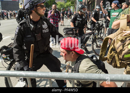 Seattle, WA, USA. 18 août, 2018. Un pistolet pro supporter soit blessée par un objet inconnu où des armes à feu et des armes à feu pro anti partisans face à l'arrêt. Crédit : Maria S./Alamy Live News. Banque D'Images