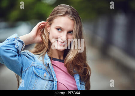 Une blonde happy girl smiles dans un style urbain. Banque D'Images