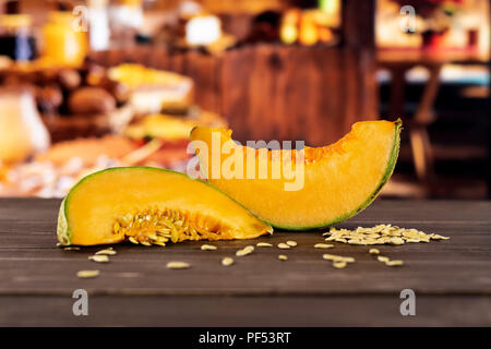 Groupe de deux tranches de melon cantaloup frais divers avec des graines autour de cuisine en bois rustique avec en arrière-plan Banque D'Images