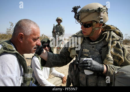 Le Sgt. Matthew Montgomery, infirmier de la 104e Compagnie médicale de soutien de secteur, 29 e division d'infanterie, de l'Armée de la Garde nationale, et un résident de Baltimore, Maryland, examine un rôle civil lecteur pendant une émeute simulation au centre de formation national, Fort Irwin, en Californie, le 15 août prochain. Les membres de la 29e ID soutiennent le centre d'instruction au combat de la rotation de la 56e Stryker Brigade Combat Team, 28e ID, Idaho Army National Guard. (U.S. La Garde nationale de l'armée photo par le Cpl. Hannah Baker/relâché). Banque D'Images