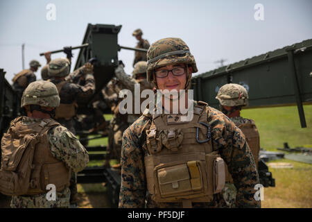 Lance le Cpl. Alexander Reverski mène des Marines et marins au cours de la phase de démontage d'un système multi-niveau opération relais 9 août 2018 au Camp Hansen, Okinawa, Japon. Marines avec Bridge Company, 9e, 3e Bataillon d'appui du Groupe logistique maritime et naval de marins avec un bataillon de construction Mobile 5 montés et démontés un pont moyen, qui est utilisé pour transporter le personnel et le matériel sur de grandes lacunes et les plans d'eau. Reverski, ingénieur de combat avec Bridge Co., 9e ESB, est un natif de Tracy, en Californie. (U.S. Marine Corps photo de la FPC. Terry Wong) Banque D'Images