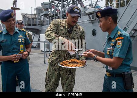 180810-N-GR847-0003 JAKARTA, INDONÉSIE (16 août 2000 10, 2018) - Le Lieutenant de la Marine américaine Anthony argile, attribué à l'île de Whidbey-class landing ship dock USS Rushmore (LSD 47), sert des cookies pour les membres de la marine indonésienne avant la réception d'accueil et de coopération en mer de l'état de préparation de la formation (CARAT) 2018 à Jakarta, Indonésie. CARAT en Indonésie, en sa 24ème itération, est conçu pour accroître l'échange d'information et de coordination, de bâtir la capacité de combat de mutuelle et favoriser à long terme la coopération régionale permettant aux deux forces armées partenaire d'opérer efficacement ensemble comme une force maritime unifié. Banque D'Images