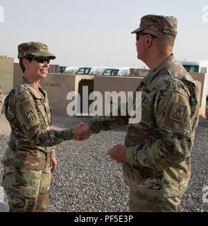 Le lieutenant-général Timothy J. Kadavy, Directeur de l'US Army National Guard, présente le colonel Kimberly M. Martindale, commandant de la 38e Brigade de maintien en puissance, avec sa pièce de la Garde nationale après sa visite à la Brigade au Camp Arifjan, au Koweït, le 10 août. Banque D'Images