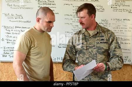 Tech. Le Sgt. Ken Supsic (à gauche), technicien en approvisionnement avec la 201e Ingénieur opérationnel rapide déployables de l'Escadron de réparation des ingénieurs, est informé de la situation rapport de Master Sgt. Daniel Steenstra, chef de projet pour le 201e RED HORSE le déploiement pour le projet de formation, le 14 avril 2018. Le SIT-REP est un composant important pour le cheval rouge équipes pour assurer la continuité d'une rotation de l'équipe à l'autre. Supsic est un membre de l'équipe de la troisième des quatre rotations Cheval Rouge voyageant à Lituanie complétant le déploiement pour la formation par la construction d'un military air-sol gamme de formation à utiliser b Banque D'Images