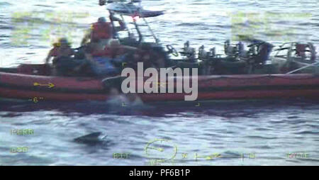 Un garde-côte de William Flores petit bateau équipage tire deux personnes de l'eau après un 25 pieds de Grady de plaisance blanc prend l'eau Vendredi, 16 août 2018 à environ 34 milles à l'est de Lake Worth, en Floride. La faucheuse William Flores équipage reçoit un appel de détresse du navire ont indiqué qu'ils étaient pris sur l'eau et l'équipage coupe détournées pour aider les plaisanciers. U.S. Coast Guard photo gracieuseté de la Garde côtière canadienne William Flores Banque D'Images