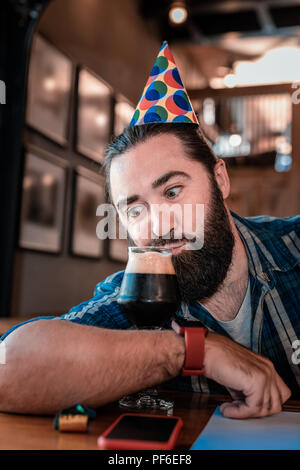 Homme barbu rigolo en sirotant une bière brune celebrating birthday Banque D'Images