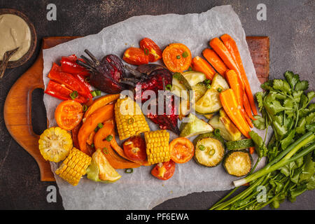 Les légumes cuits : citrouille, betteraves, carottes, poivrons, courgettes et maïs, vue de dessus, l'arrière-plan sombre. Banque D'Images