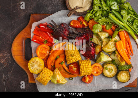 Les légumes cuits : citrouille, betteraves, carottes, poivrons, courgettes et maïs, vue de dessus, l'arrière-plan sombre. Banque D'Images