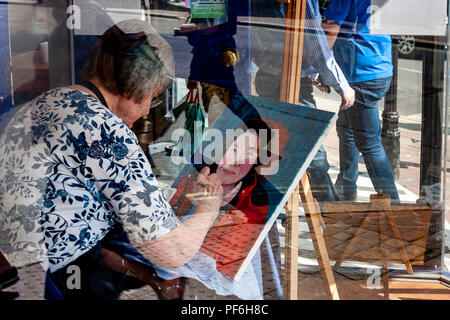 Un artiste de la peinture d'une photo dans une vitrine, Lewes, dans le Sussex, UK Banque D'Images