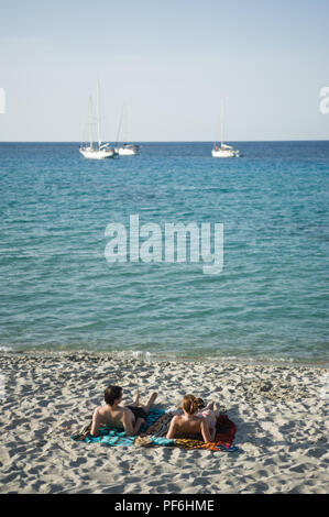 Deux touristes de soleil sur Plage de Ginepara beach à l'Île-Rousse, Corse, France, Europe Banque D'Images