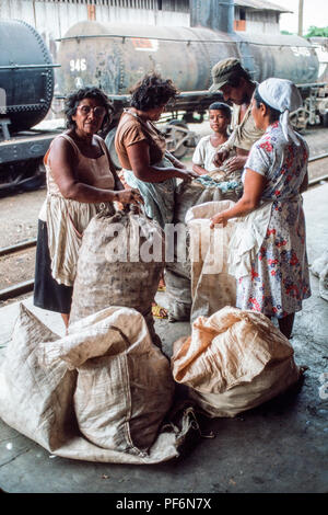 Managua, Nicaragua, 12 février 1990 ; les femmes ont leurs sacs de produire vérifié après déchargement d'un train de marchandises par chemin de fer à Managua. Banque D'Images