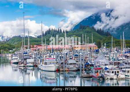 Gros nuages blancs avec des taches de ciel bleu sur petit bateau sur le port du Prince William en Alaska Valdez Banque D'Images