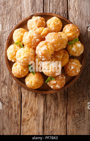 Chouquettes dessert Profiteroles français est décoré de sucre perlé et menthe libre sur une table. Haut Vertical Vue de dessus Banque D'Images