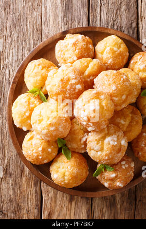 Dessert profiteroles chouquette française avec du sucre perlé et menthe libre sur la table. Haut Vertical Vue de dessus Banque D'Images