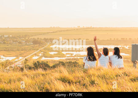 ETULIA, MOLDOVA - août 03, 2018 : Groupe de trois filles pour le coucher du soleil sur une colline à la campagne, de saut et de smiling Banque D'Images