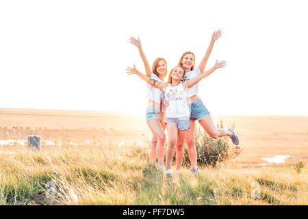 ETULIA, MOLDOVA - août 03, 2018 : Groupe de trois filles pour le coucher du soleil sur une colline à la campagne, de saut et de smiling Banque D'Images