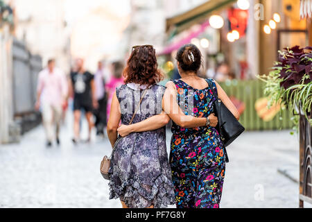 Lviv, Ukraine - le 30 juillet 2018 : deux de l'Europe de l'est slaves ukrainiennes à dos, les bras autour de l'autre hugging holding dans la ville historique de l'Ukraine Banque D'Images