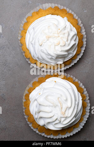 Délicieux blanc merengue dessert. Tartelette citron tarte de meringue avec pierre béton gris sur fond de table Banque D'Images