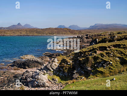 Vue sur le rivage de la baie rocheuse, Achnahaird Coigach, les Highlands écossais, à Inverpolly montagnes à l'horizon. Banque D'Images