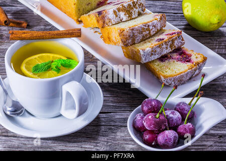 Thé au citron gingembre, menthe et cherry cake, gros plan Banque D'Images