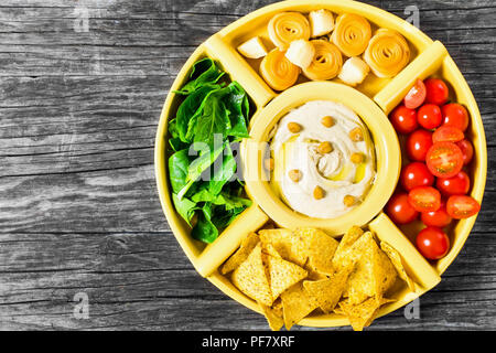 Maison saine délicieux hummus épicé avec de jeunes carottes, céleri, épinards, gingembre, tranches de lime, l'huile d'olive vierge, les noix de pin et de pain pita, à Banque D'Images