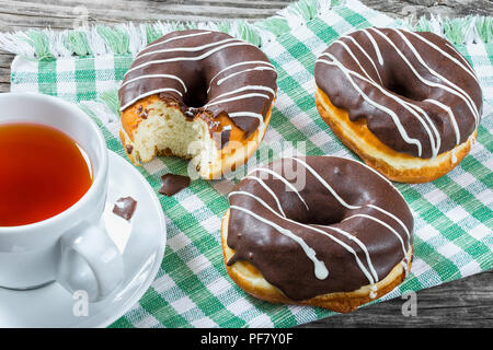 Donuts avec glaçage au chocolat, une tasse de thé, vue du dessus Banque D'Images