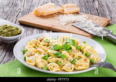 Tortellini avec les pois verts, les noix de pin, le parmesan et supérieure Banque D'Images