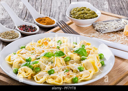 Tortellini avec les pois verts, les noix de pin, le parmesan et supérieure Banque D'Images