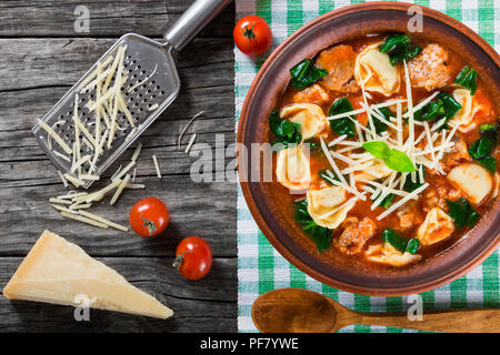 Soupe tortellini avec saucisses italiennes, épinards, tomates, fromage parmesan , top-view Banque D'Images