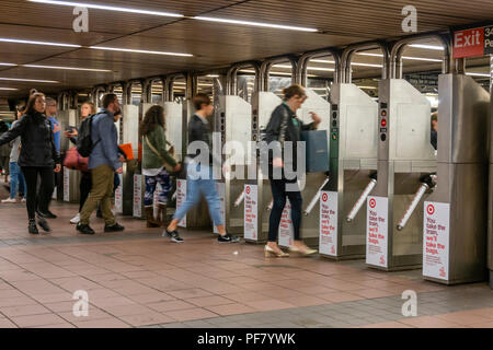 Se rendre à travers les tourniquets dans une station de métro à New York City Banque D'Images