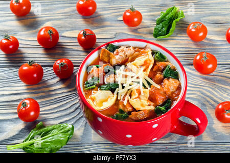 Soupe tortellini avec saucisses italiennes, épinards, tomates, fromage parmesan Banque D'Images