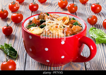 Soupe tortellini avec saucisses italiennes, épinards, tomates, fromage parmesan Banque D'Images