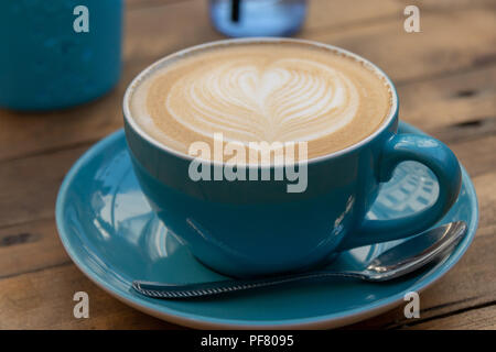 Café Latte en bleu mug sur la table en bois Banque D'Images