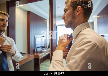 Les personnes, entreprises,la mode et l'habillement concept - close up de l'homme en s'habillant avec chemise et cravate de réglage sur le cou à la maison. Banque D'Images