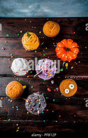 Funny children's traite pour l'Halloween : variations de cupcakes, décoré sous la forme de différents monstres, sorcières, citrouilles, fantômes. Cuisson Banque D'Images