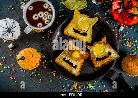 Funny children's traite pour l'Halloween, une idée pour un petit déjeuner de fête. Sandwiches pain perdu aux œufs, à la recherche comme des monstres creepy, chocolat chaud avec m Banque D'Images