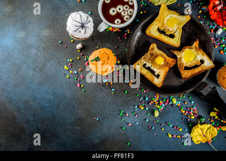 Funny children's traite pour l'Halloween, une idée pour un petit déjeuner de fête. Sandwiches pain perdu aux œufs, à la recherche comme des monstres creepy, chocolat chaud avec m Banque D'Images