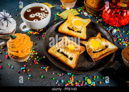 Funny children's traite pour l'Halloween, une idée pour un petit déjeuner de fête. Sandwiches pain perdu aux œufs, à la recherche comme des monstres creepy, chocolat chaud avec m Banque D'Images