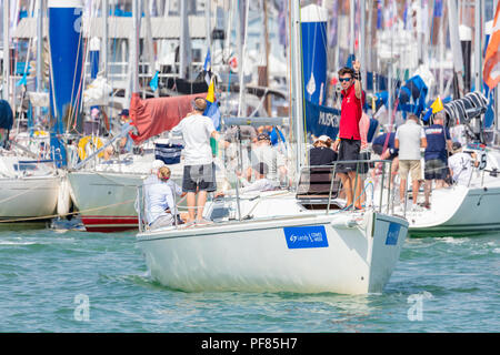 Cowes (île de Wight ; 7 août 2018 ; l'homme en rouge s'élève à Polo Yacht de Bow à la caméra pour qu'il laisse à quai. De nombreux autres bateaux disponibles derrière Banque D'Images