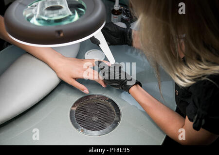 Réduit le coiffeur bar à ongles pour une manucure au salon de beauté. Traitement des ongles de doigt, le meulage et le polissage. Manucure mains Faire Femme manucure avec un coupe-ongles dans le salon de manucure Banque D'Images