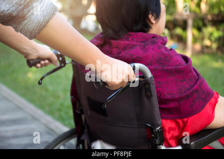 Poussant gardien senior woman en fauteuil roulant Banque D'Images