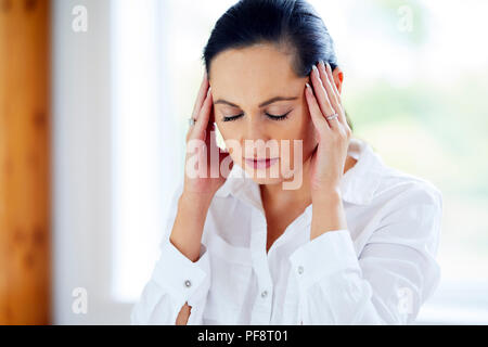 Woman rubbing her temples Banque D'Images