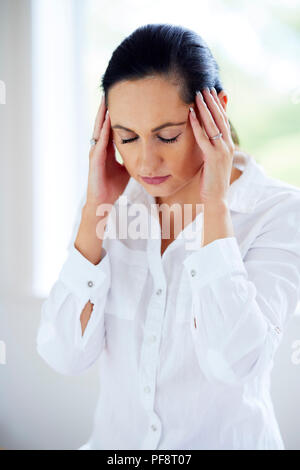 Woman rubbing her temples Banque D'Images