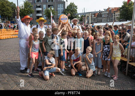 Alkmaar, Pays-Bas - 20 juillet 2018 : Groupe de transporteurs fromage posant avec une classe de l'école des enfants sur le marché du fromage Banque D'Images