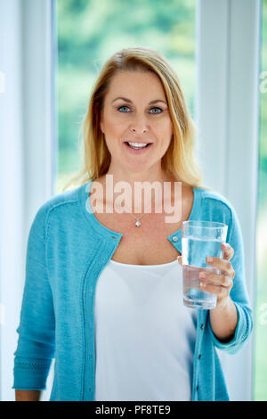 S Femme tenant un verre d'eau Banque D'Images