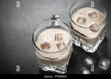 Boisson à la crème irlandaise dans les verres avec de la glace sur le noir. Banque D'Images