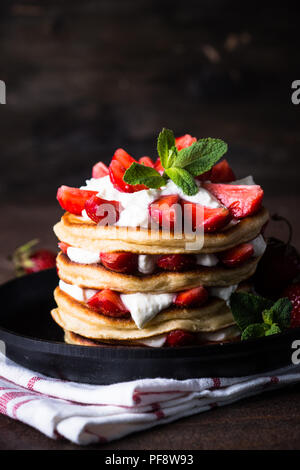 Gâteau de crêpes au mascarpone et les fraises. Fond rustique foncé. Banque D'Images