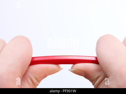 Deux mains tenant un crayon rouge à propos de prendre sous la pression. Notion de stress, de la colère, la pression sur le lieu de travail, d'être parent et breakd Banque D'Images