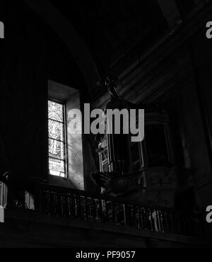 Orgue de l'église ancien éclairé par la lumière filtrée à travers un vitrail. Converti en noir et blanc. Photo ISO élevé. Banque D'Images